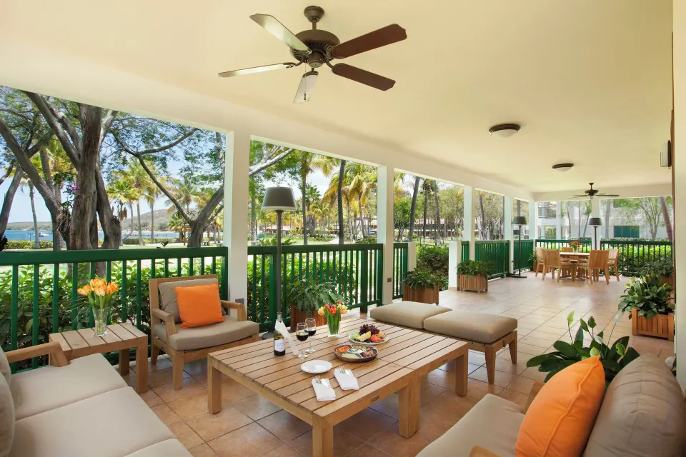 Covered terrace lounge with seating and garden views at Copamarina Beach Resort & Spa.