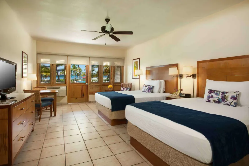 Guest room with two beds and louvered windows at Copamarina Beach Resort & Spa.