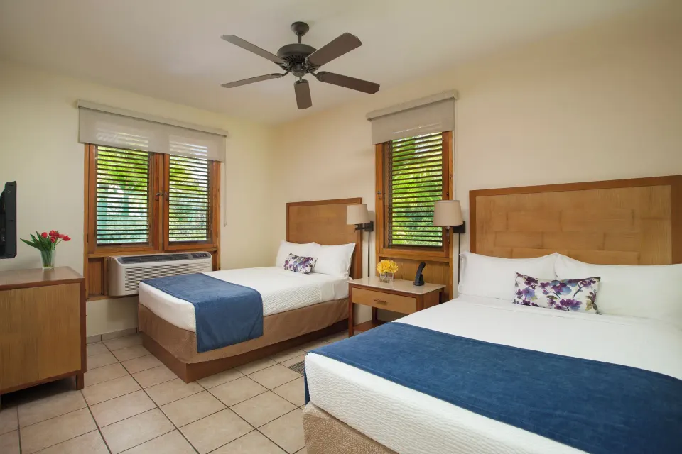 Guest room with two beds and garden-filtered windows at Copamarina Beach Resort & Spa.