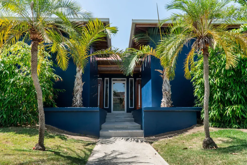 Blue building entrance framed by palm trees at Copamarina Beach Resort & Spa.