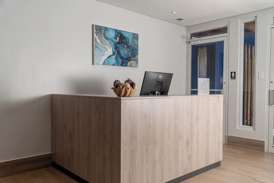 Reception desk with wall art and wood finishes at Copamarina Beach Resort & Spa.