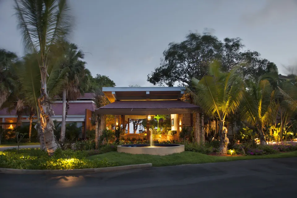 Illuminated resort entrance with palm landscaping at Copamarina Beach Resort & Spa.
