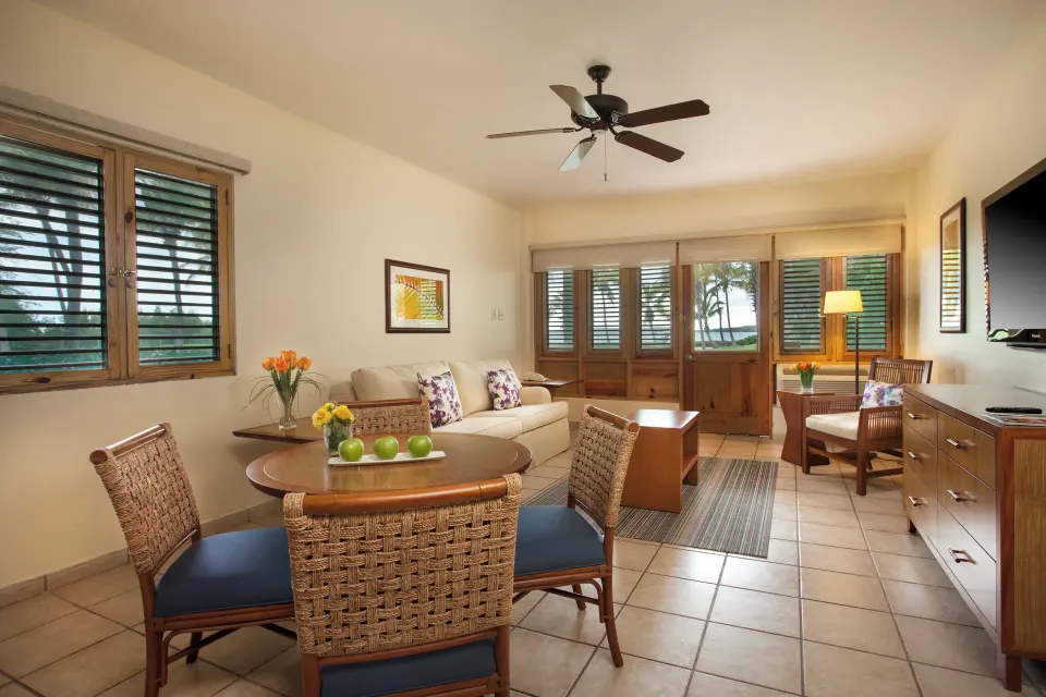 Living area with wicker chairs and shuttered windows at Copamarina Beach Resort & Spa.