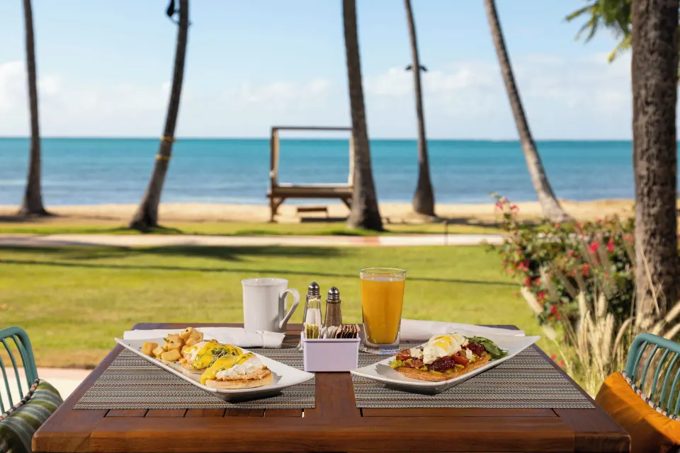 Breakfast plates on an outdoor table facing the beach at Copamarina Beach Resort & Spa.