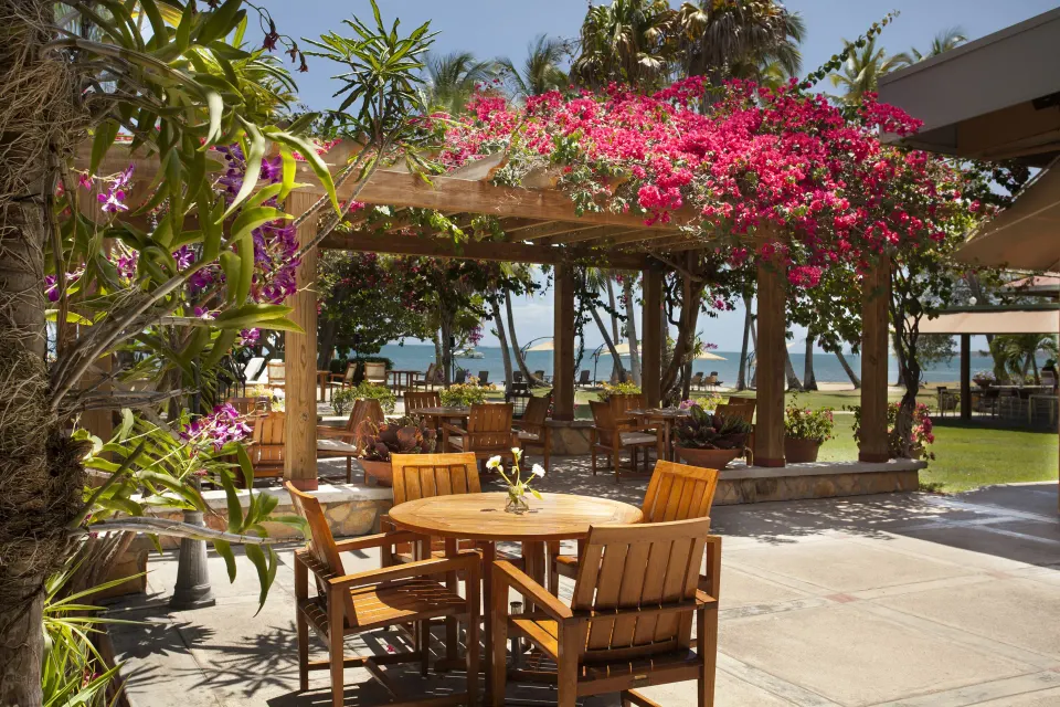 Garden dining table under flowering vines at Copamarina Beach Resort & Spa.