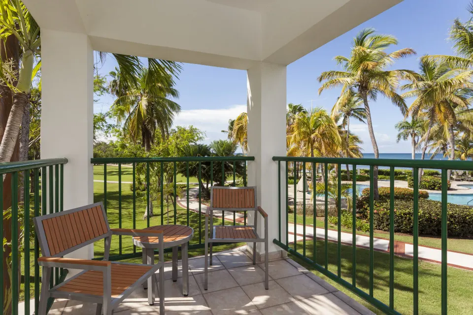 Deluxe Ocean View Room balcony with seating and palm-framed ocean view at Copamarina Beach Resort & Spa.