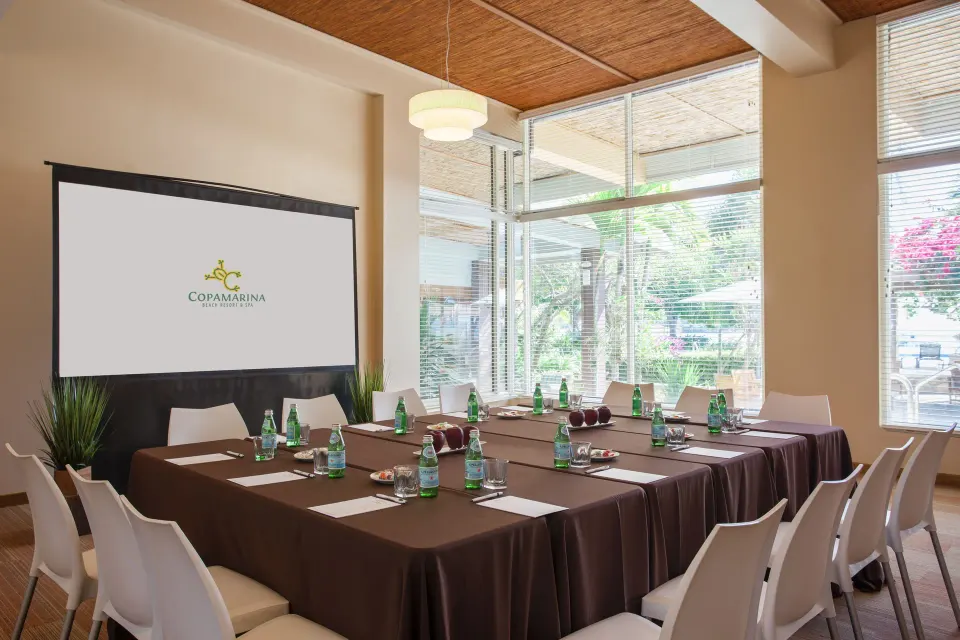 Meeting room with U-shaped tables and presentation screen at Copamarina Beach Resort & Spa.