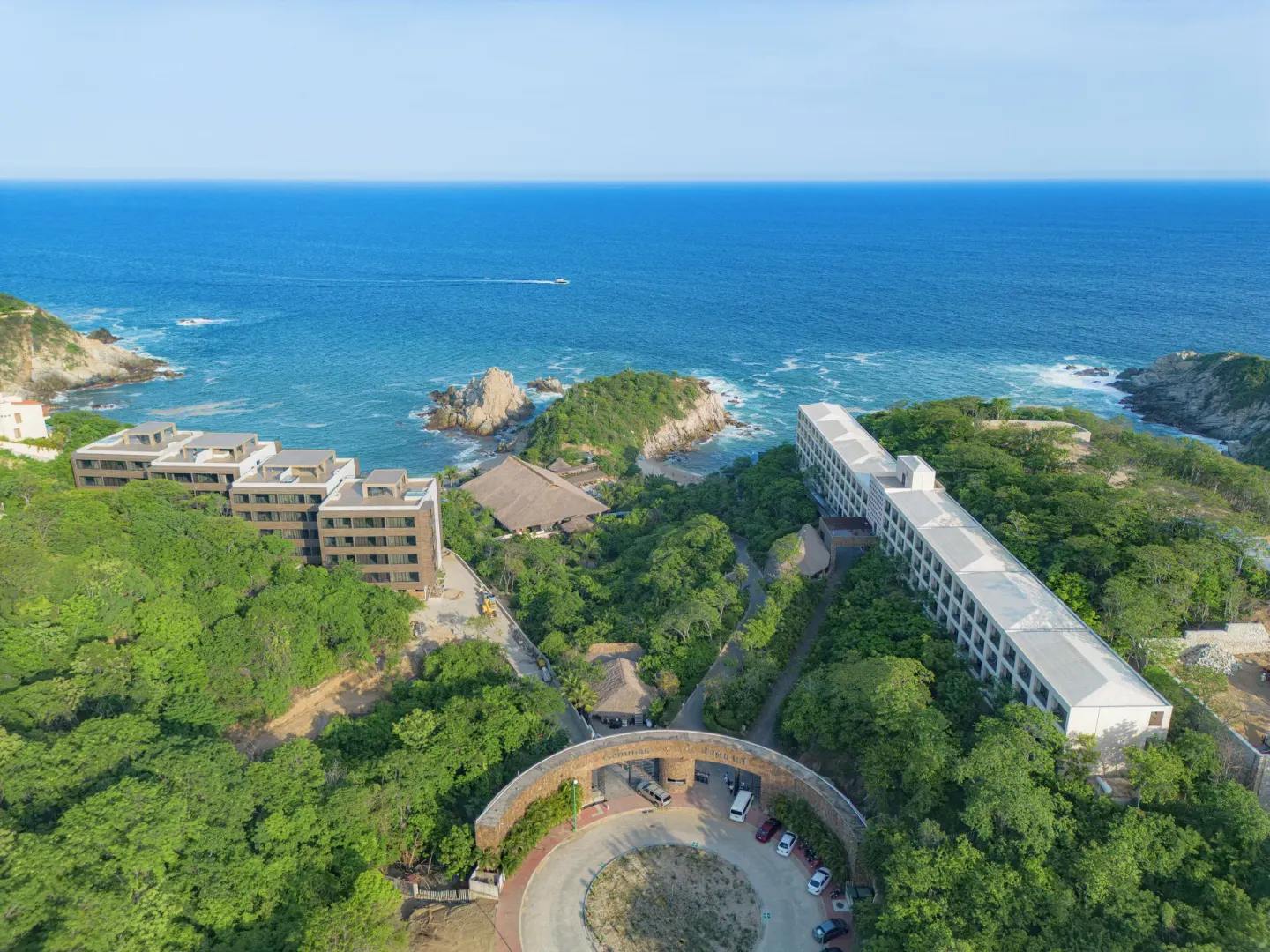 Aerial view of Coral Blue Huatulco buildings, rocky coves, and the Pacific Ocean.