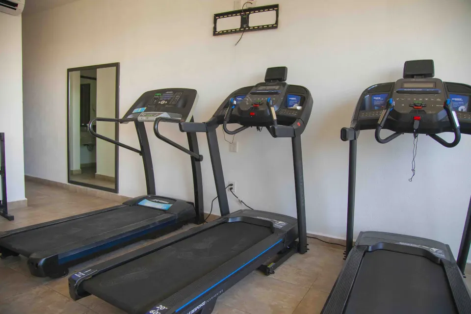 Fitness room treadmills lined along a wall at Coral Blue Huatulco.