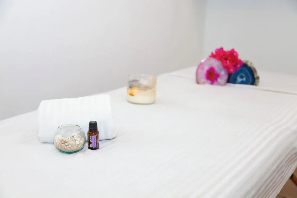 Spa treatment bed with towels, candle, flowers, and oil at Coral Blue Huatulco.