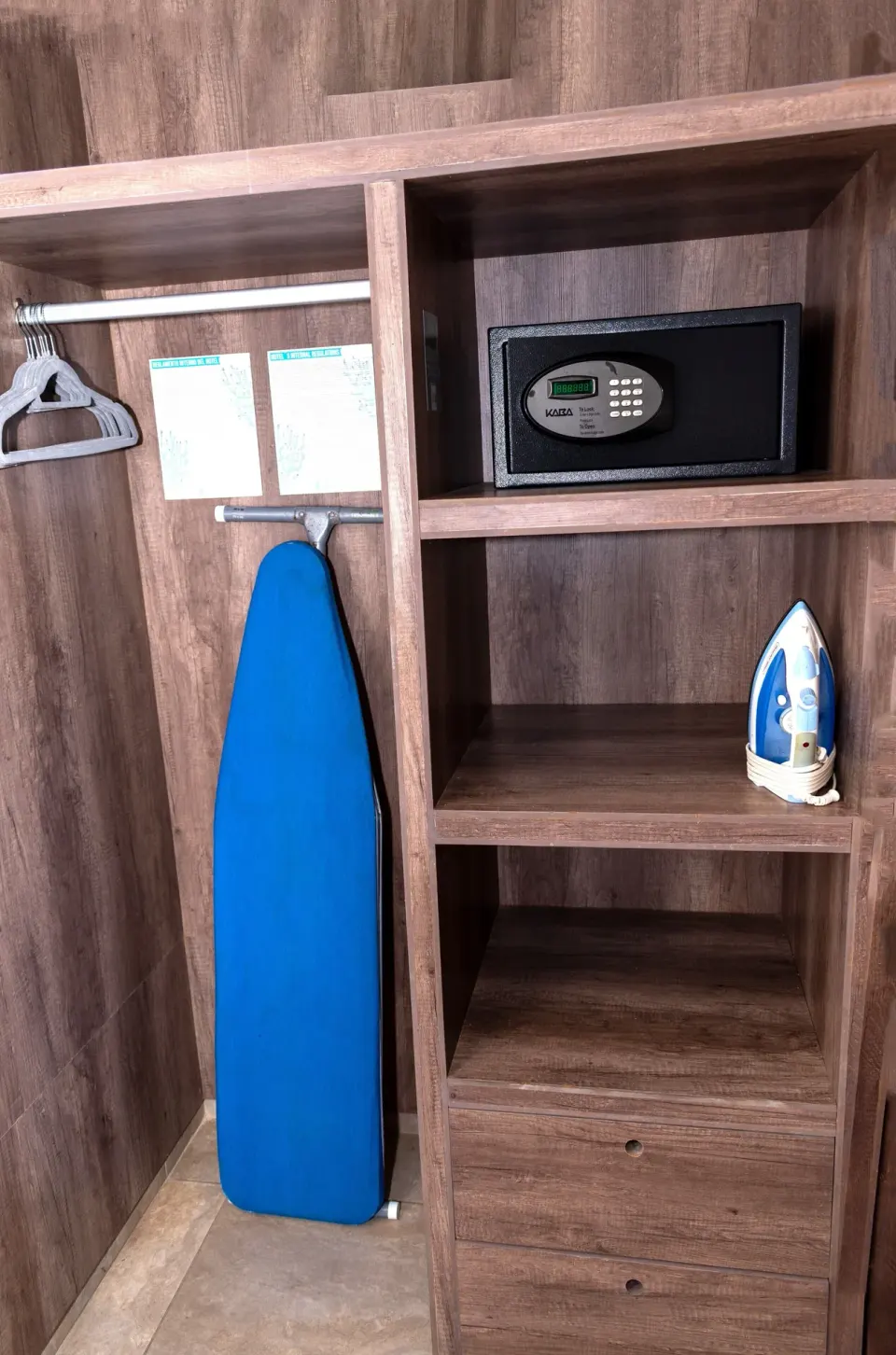 Open closet with safe, hangers, ironing board and iron in a Deluxe Room at Coral Blue Huatulco.