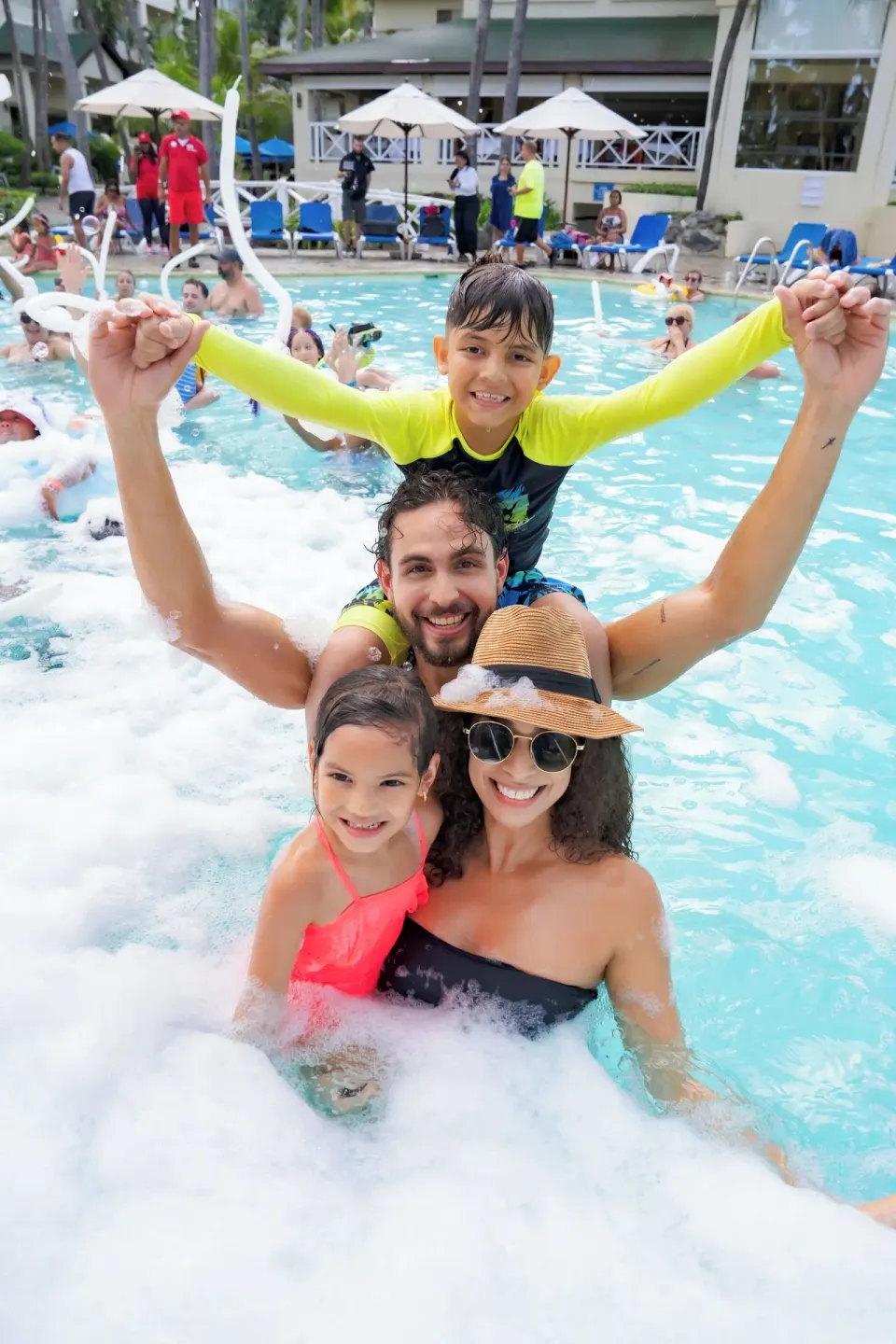 A family poses in a foamy pool activity at Coral Costa Caribe Beach Resort.