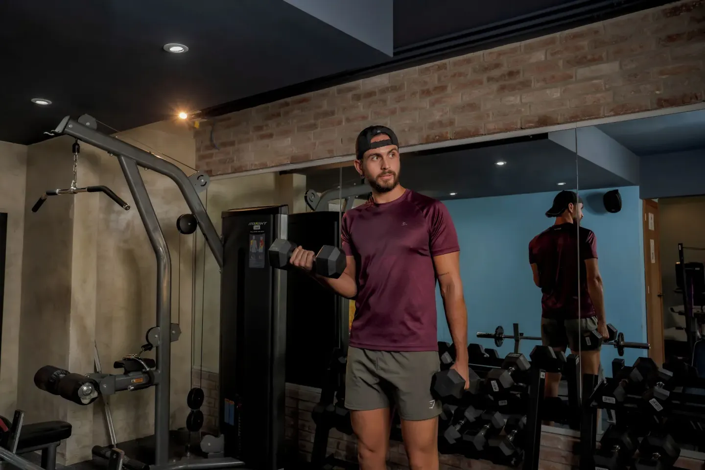 Guest lifting dumbbells beside mirrors in the gym at Coral Costa Caribe Beach Resort.