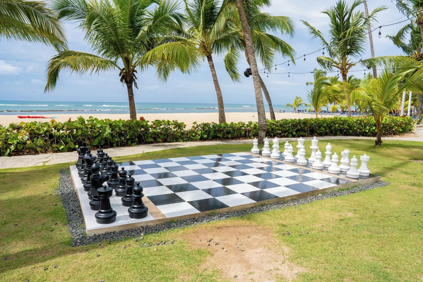 Giant chessboard on a palm lawn by the beach at Coral Costa Caribe Beach Resort.