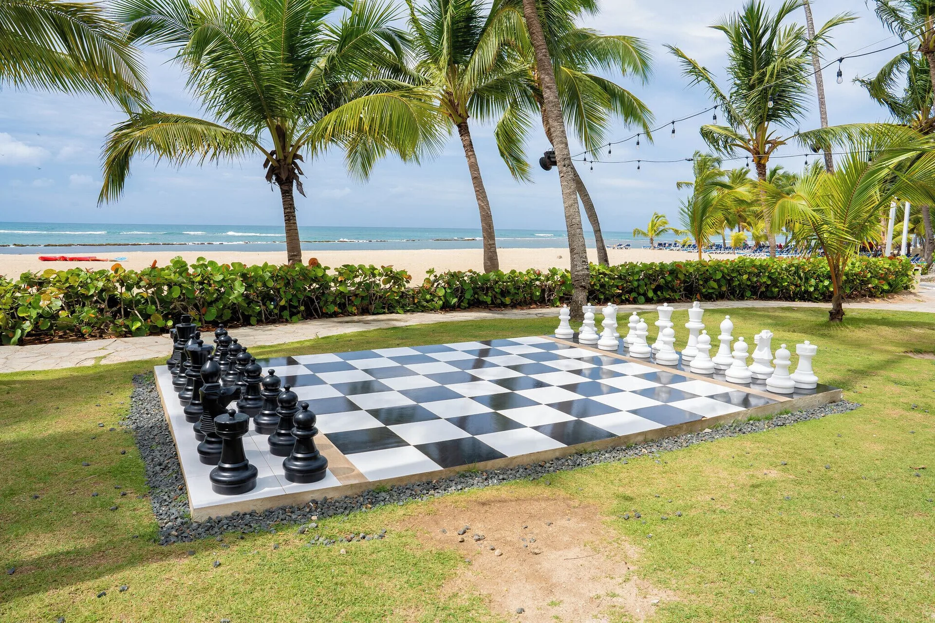 Giant chessboard on a palm lawn by the beach at Coral Costa Caribe Beach Resort.