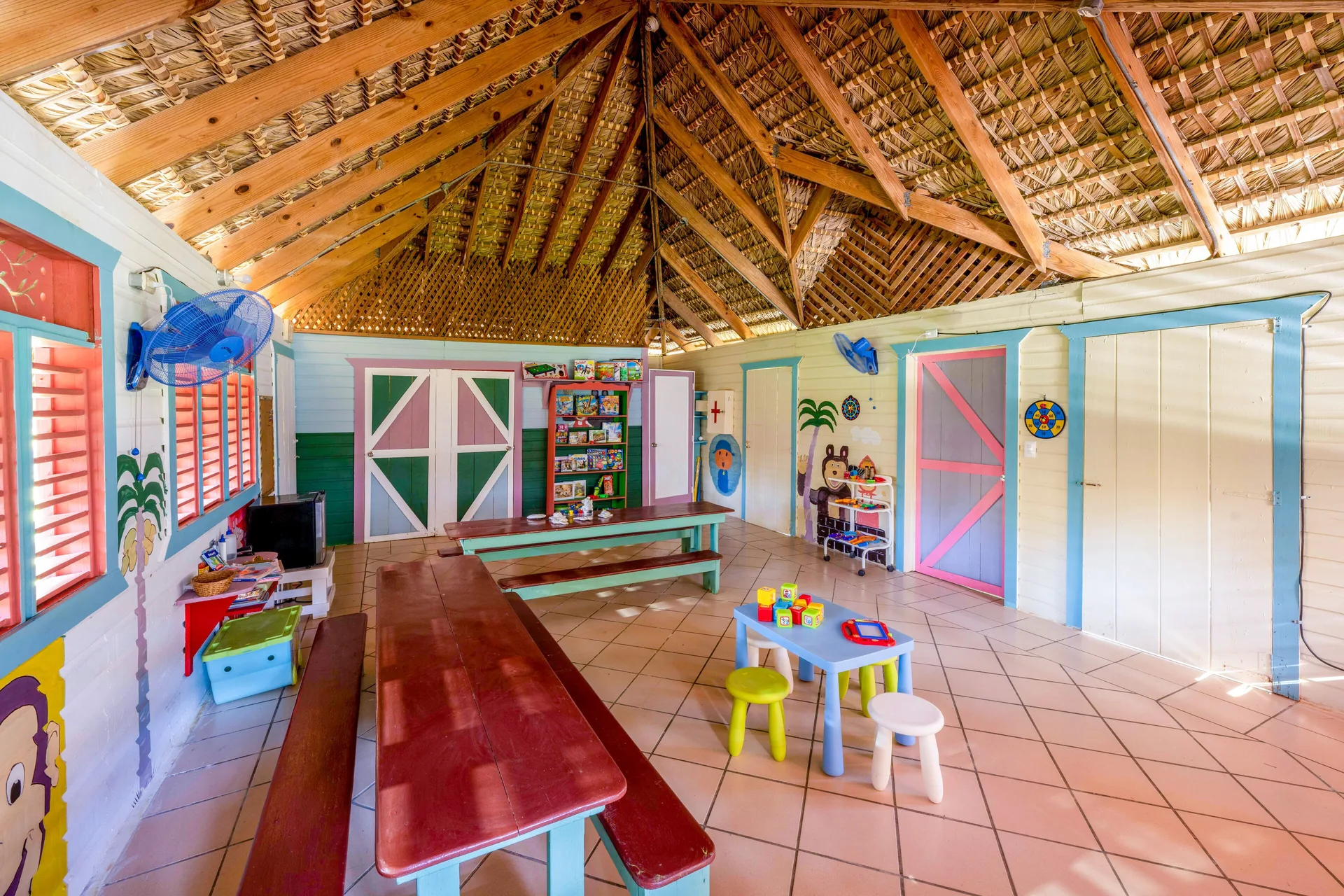 The Kids Club interior has benches, toys, and a thatched ceiling at Coral Costa Caribe Beach Resort.
