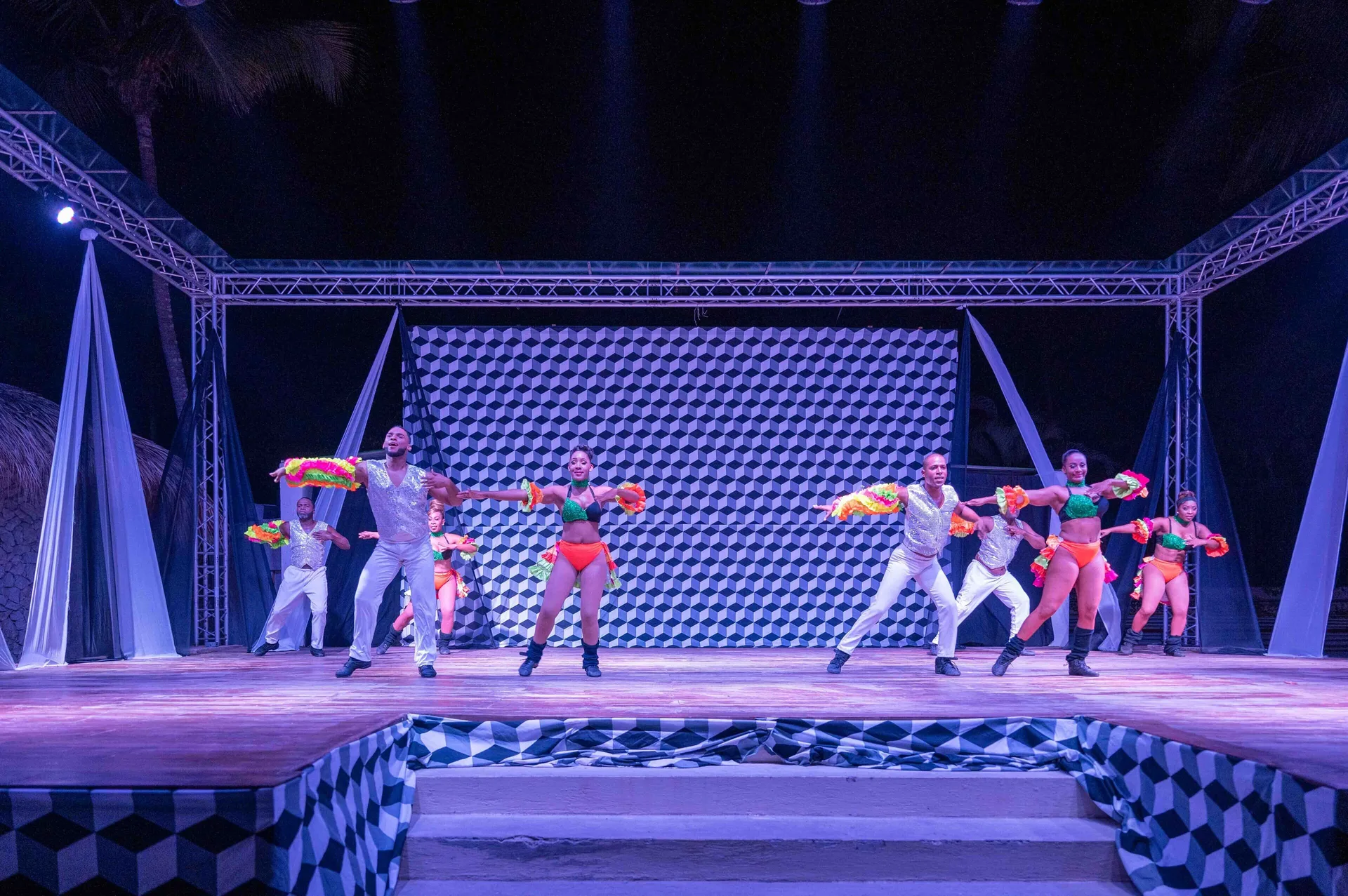 Costumed dancers face the audience on an outdoor stage at Coral Costa Caribe Beach Resort.