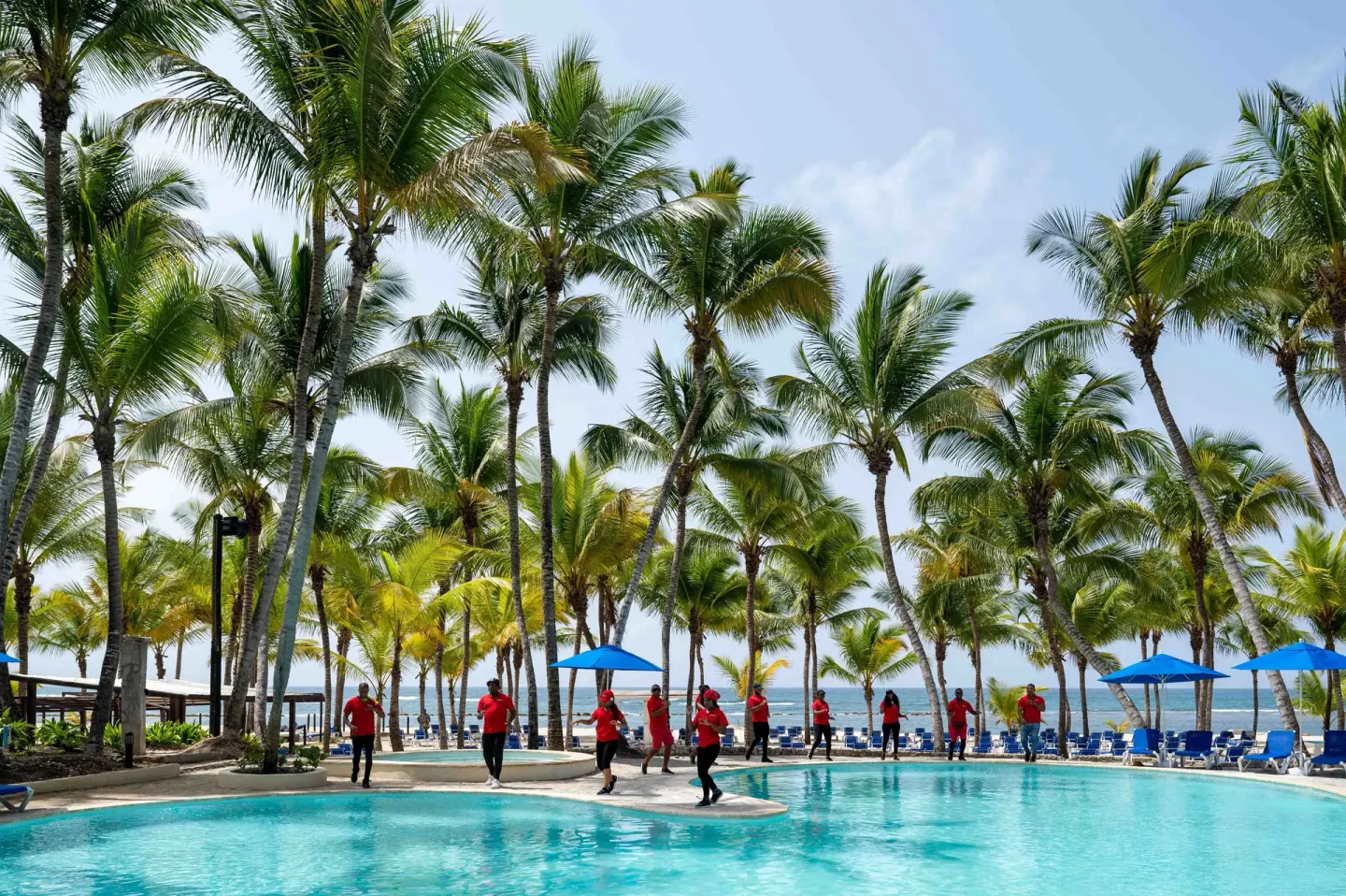 Poolside activity class under palm trees at Coral Costa Caribe Beach Resort.