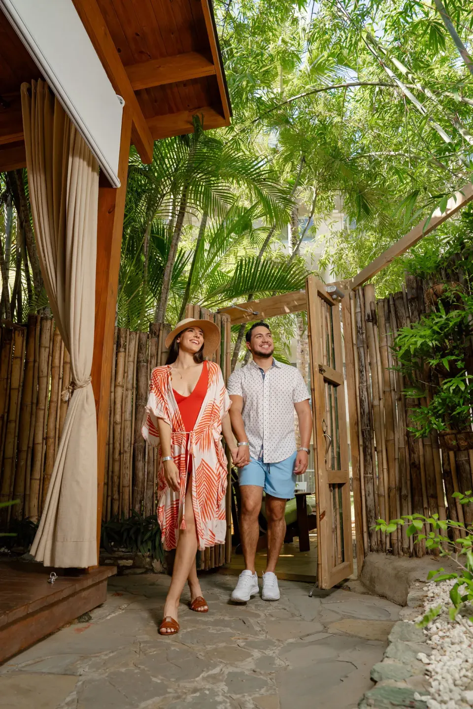 Couple walking through a tropical bamboo garden path at Coral Costa Caribe Beach Resort.