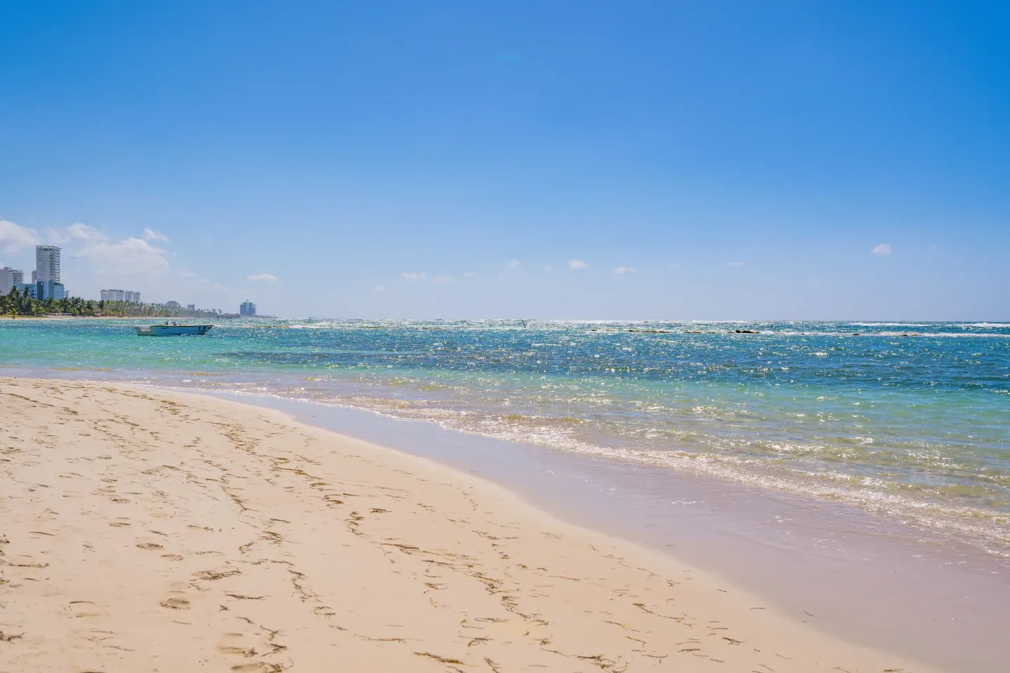 Sandy beach and turquoise shoreline near Coral Costa Caribe Beach Resort.