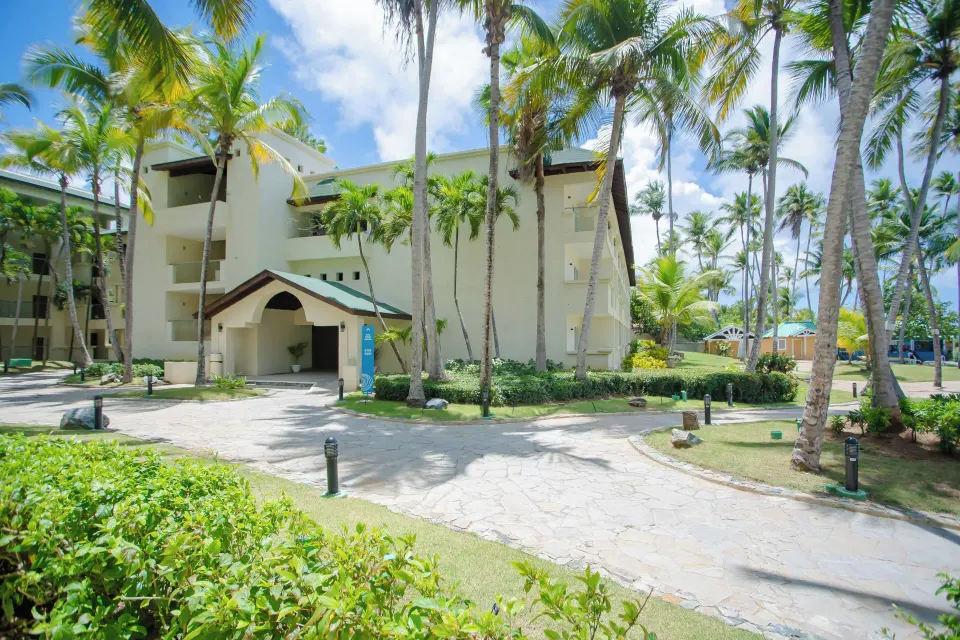 Palm-lined guest room building and garden paths at Coral Costa Caribe Beach Resort.