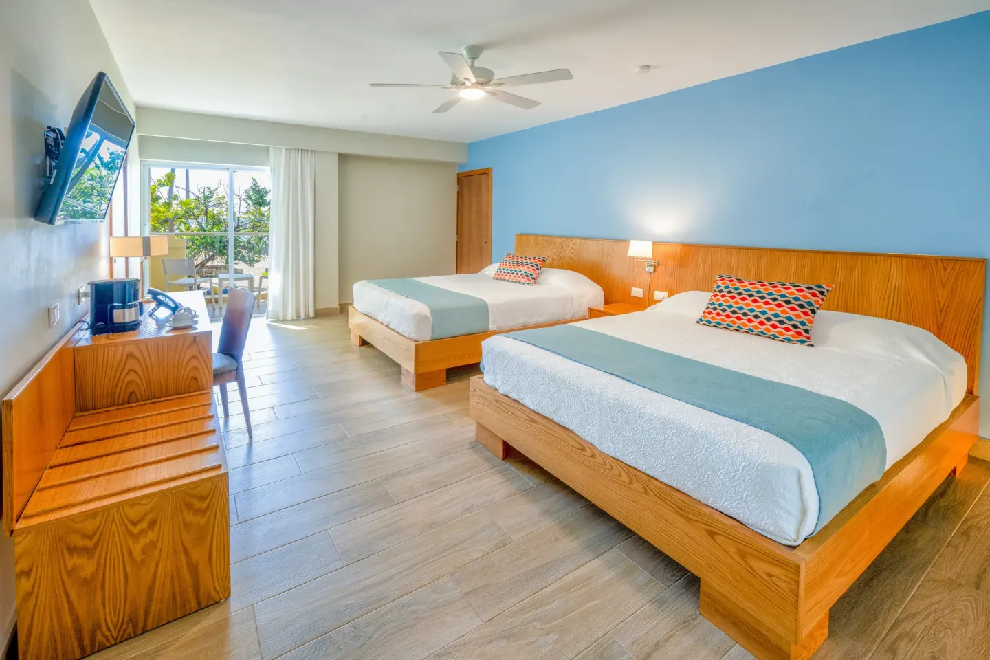 Deluxe ocean view room with two beds and balcony at Coral Costa Caribe Beach Resort.