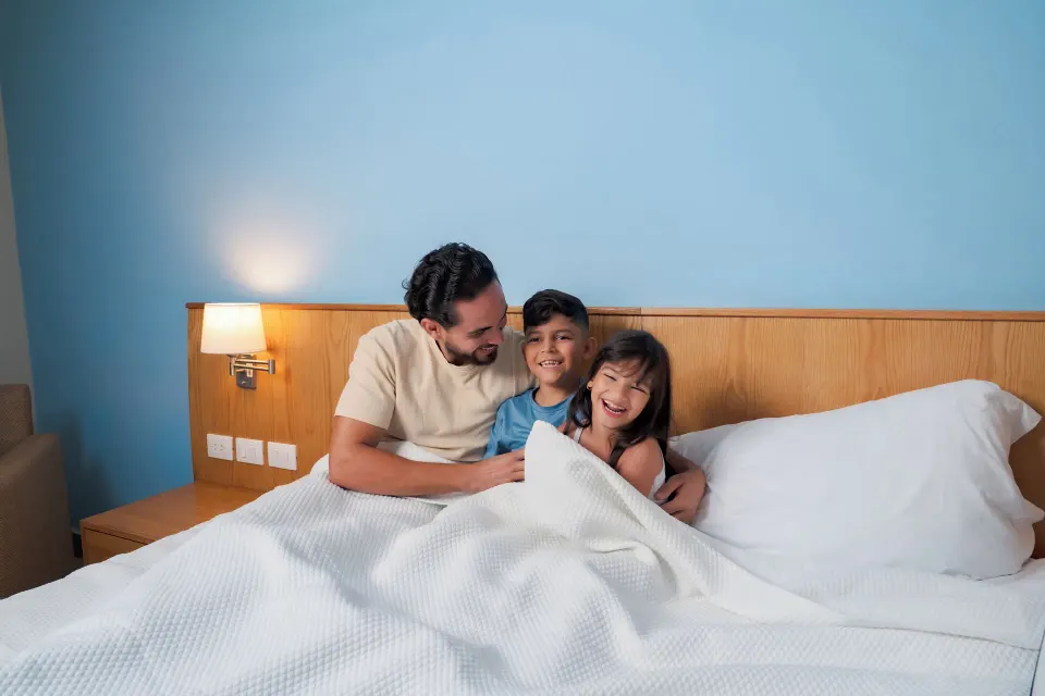 Adult and children relaxing in a Standard Room Garden View bed at Coral Costa Caribe Beach Resort