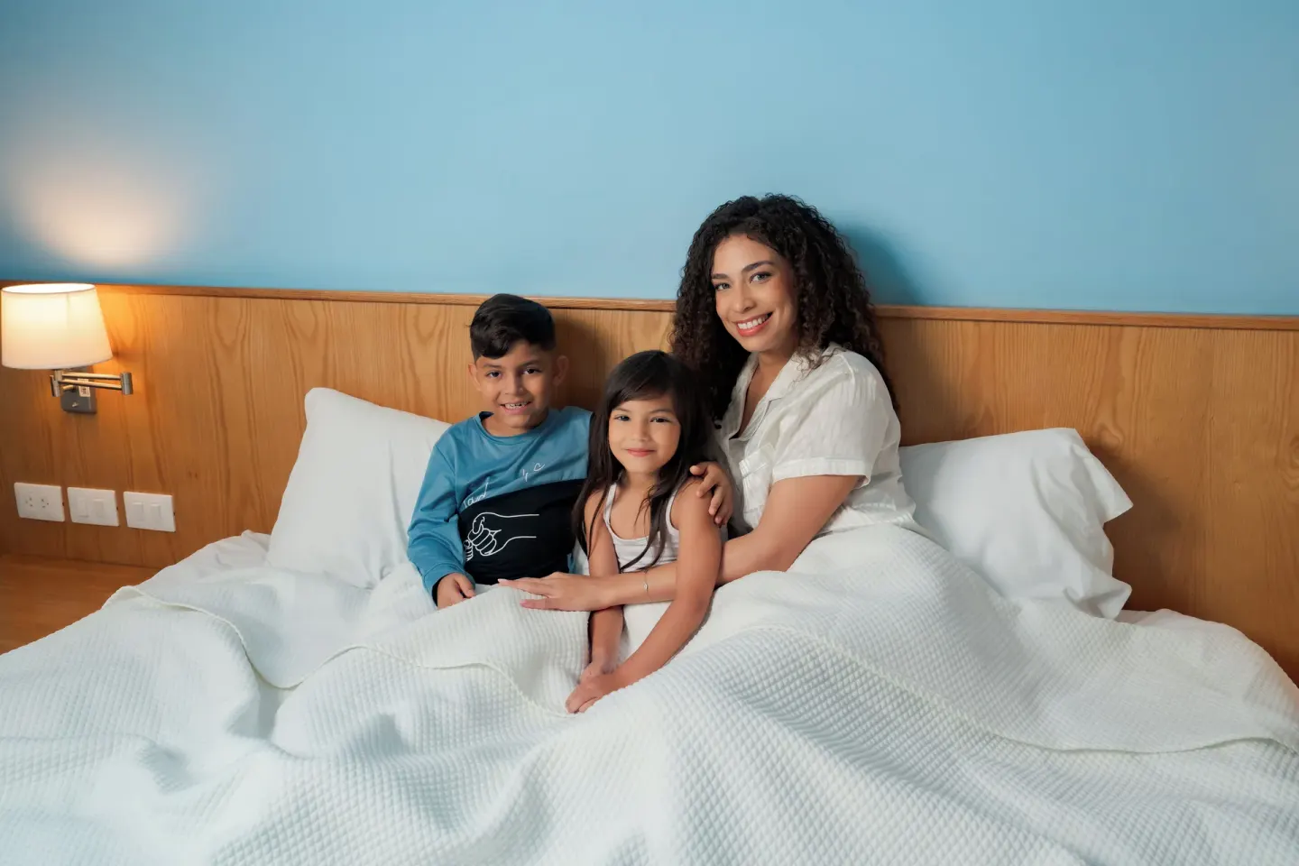 Family seated in a Standard Room Garden View bed at Coral Costa Caribe Beach Resort