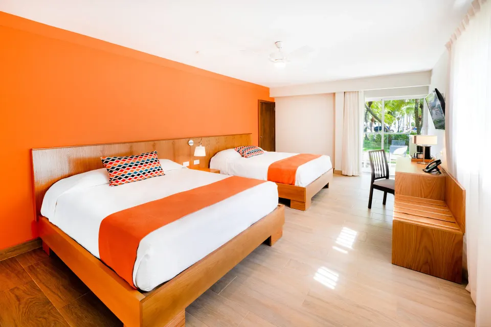 Superior Room with two beds and garden-facing balcony at Coral Costa Caribe Beach Resort.
