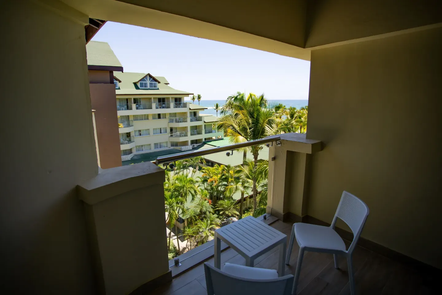 Superior Room balcony with ocean and palm views at Coral Costa Caribe Beach Resort.