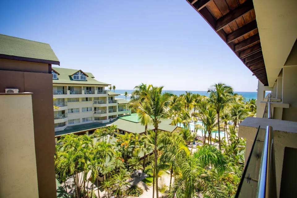 Superior Room balcony view over palms and ocean at Coral Costa Caribe Beach Resort.