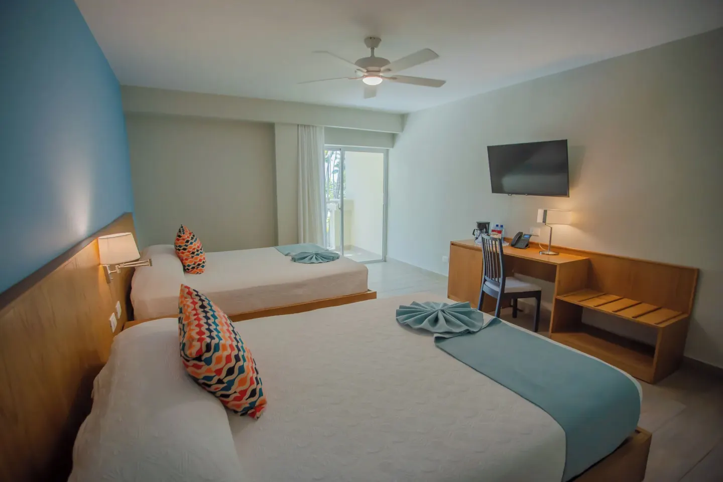 Superior Room with two beds and balcony doors at Coral Costa Caribe Beach Resort.