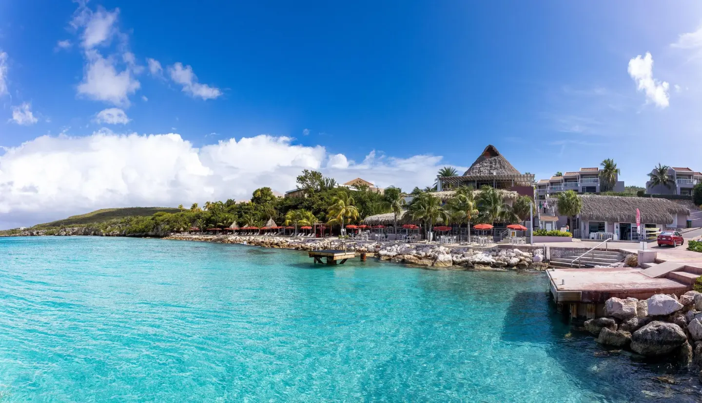 Waterfront resort buildings and turquoise bay at Coral Estate Luxury Resort.