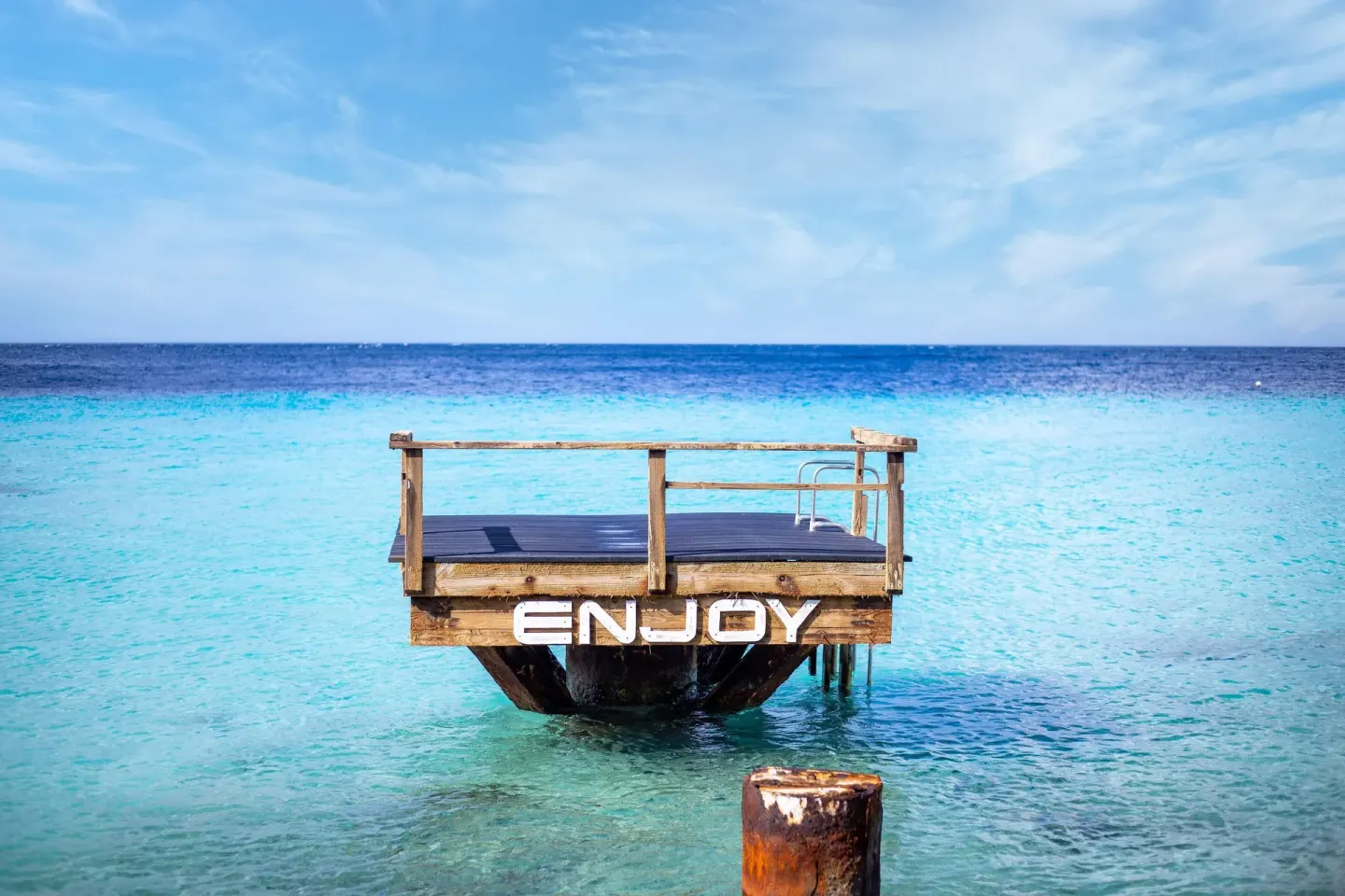 Small wooden swim platform over clear blue water at Coral Estate Luxury Resort.