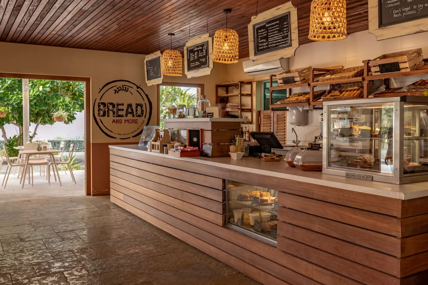Bread And More cafe counter with pastry displays and menu boards at Coral Estate Luxury Resort.