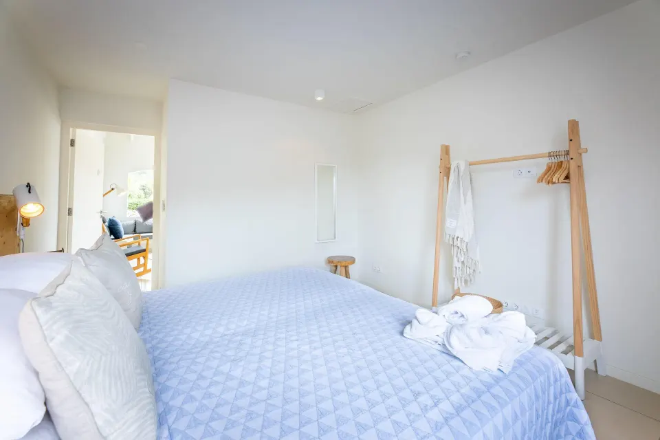 Deluxe apartment bedroom with robe rack and open doorway at Coral Estate Luxury Resort.