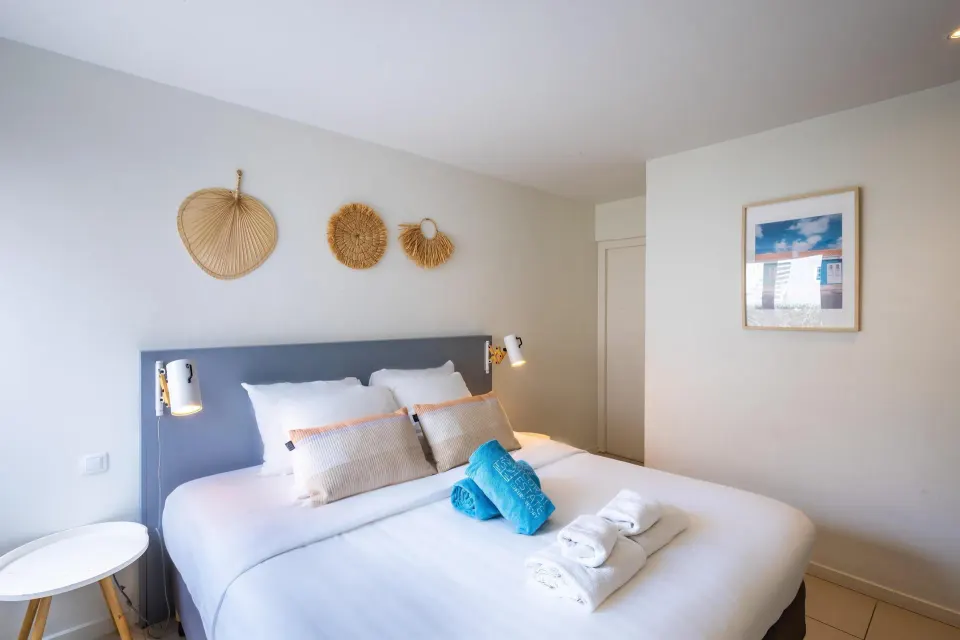 Bedroom with a double bed and woven wall decor at Coral Estate Luxury Resort.