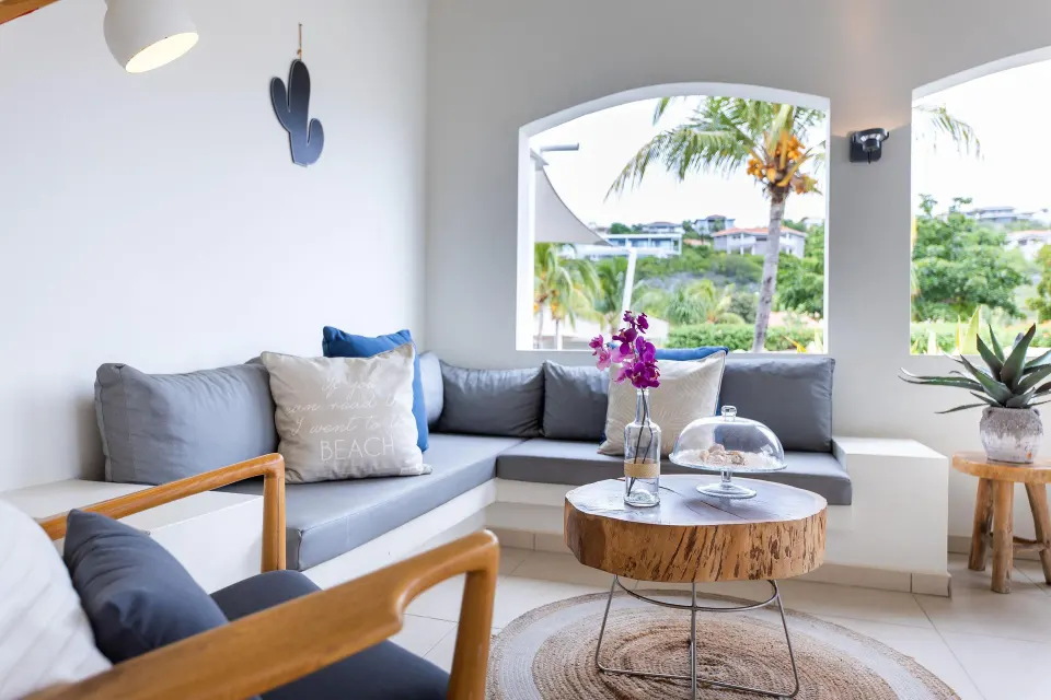 Garden-view apartment lounge with gray sofas at Coral Estate Luxury Resort.