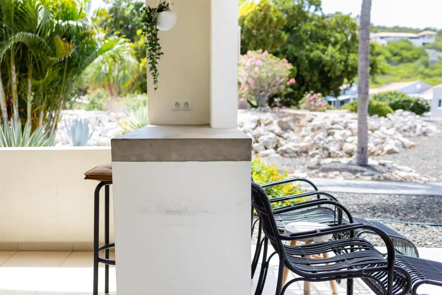 Outdoor chairs and garden view on an apartment terrace at Coral Estate Luxury Resort.