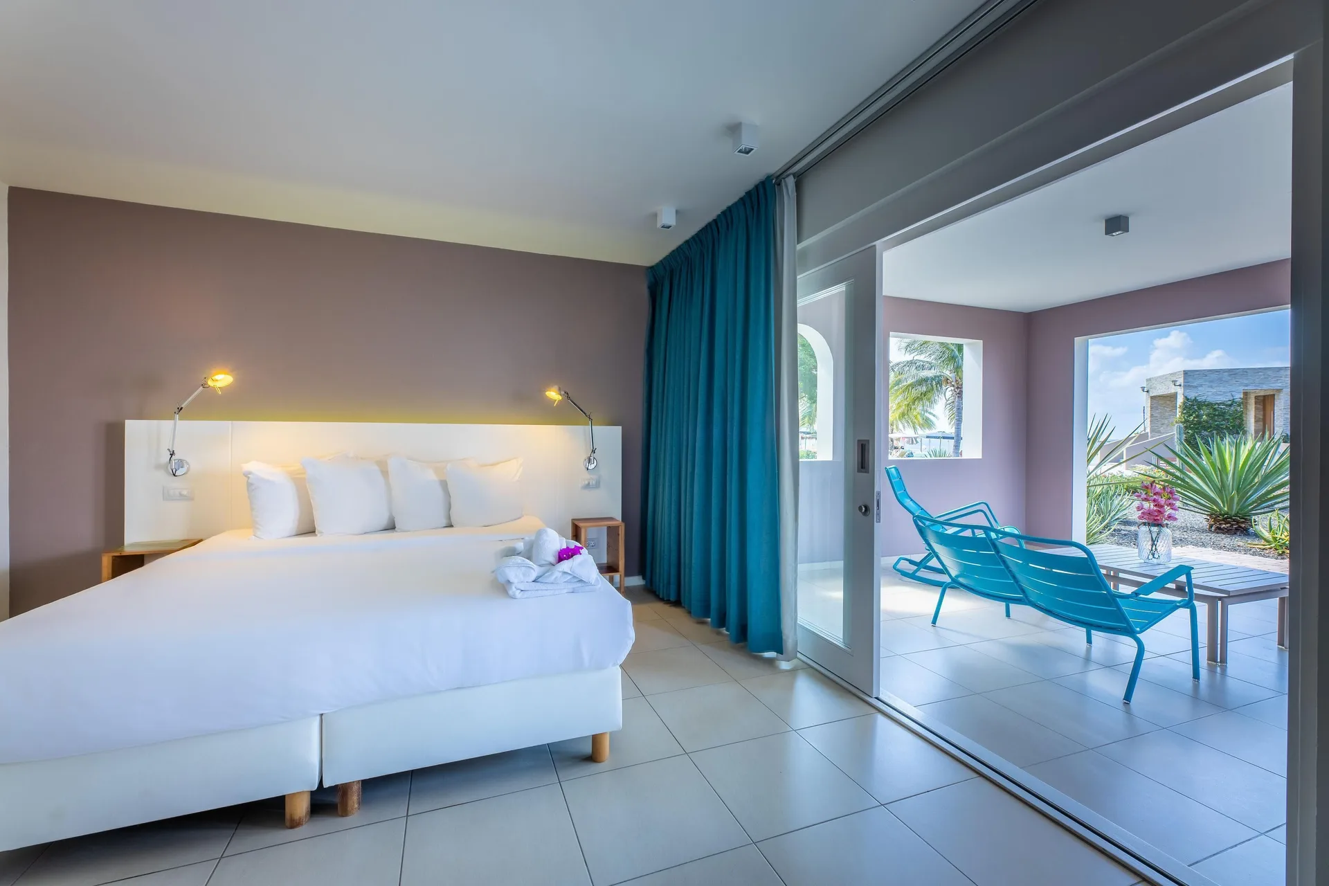 Deluxe Room Garden View bed and terrace at Coral Estate Luxury Resort.