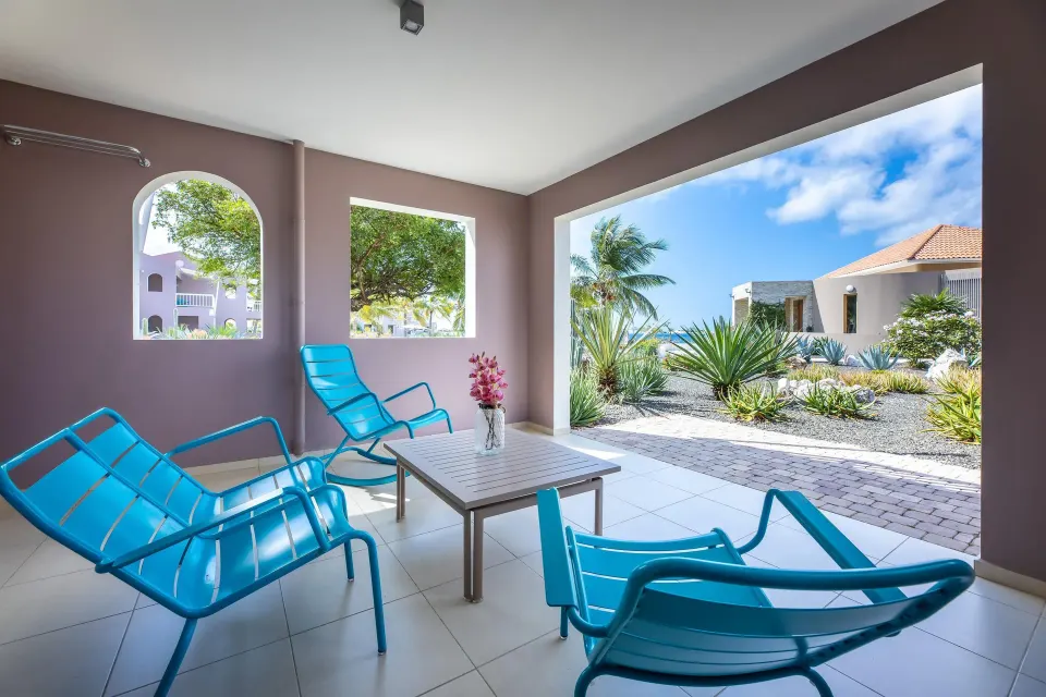 Deluxe Room Garden View terrace with blue chairs at Coral Estate Luxury Resort.