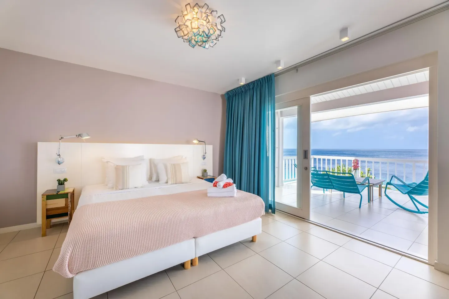 Deluxe Room Ocean View king bed and balcony at Coral Estate Luxury Resort.