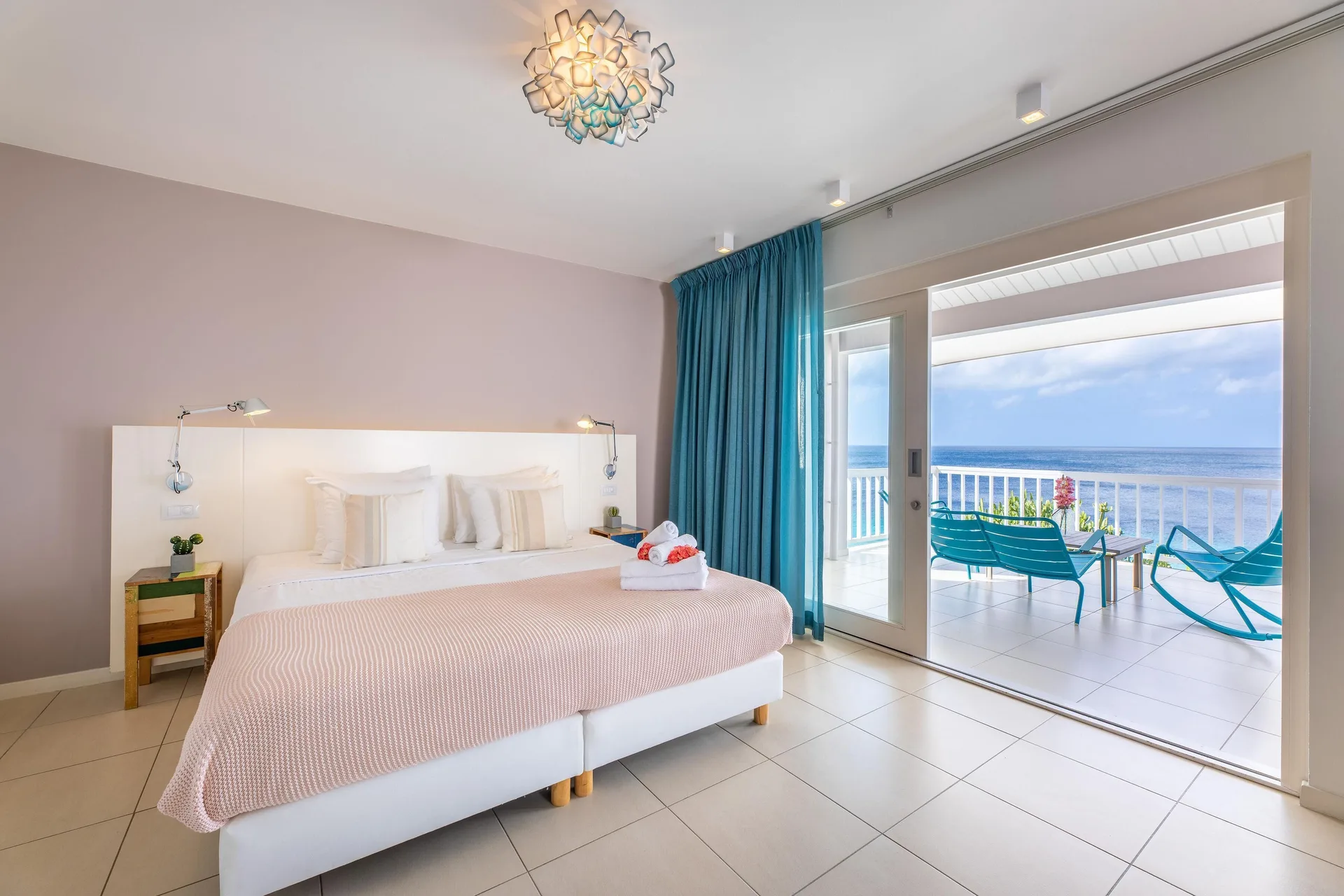 Deluxe Room Ocean View king bed and balcony at Coral Estate Luxury Resort.
