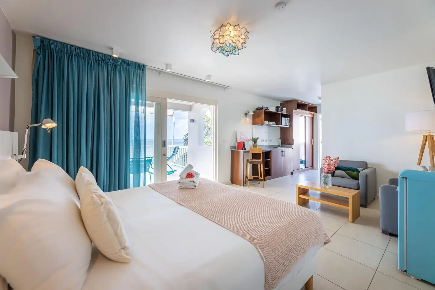 Deluxe Room king bed, kitchenette, sitting area, and balcony at Coral Estate Luxury Resort.