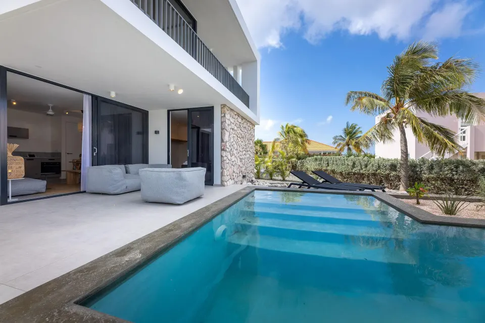 Premium Villa private pool beside shaded seating and palms at Coral Estate Luxury Resort.