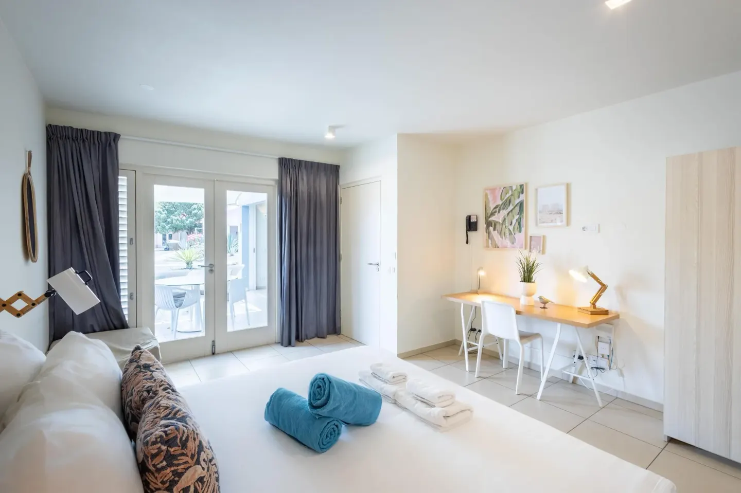 Superior Apartment bedroom with patio doors, bed, desk, and wardrobe at Coral Estate Luxury Resort.