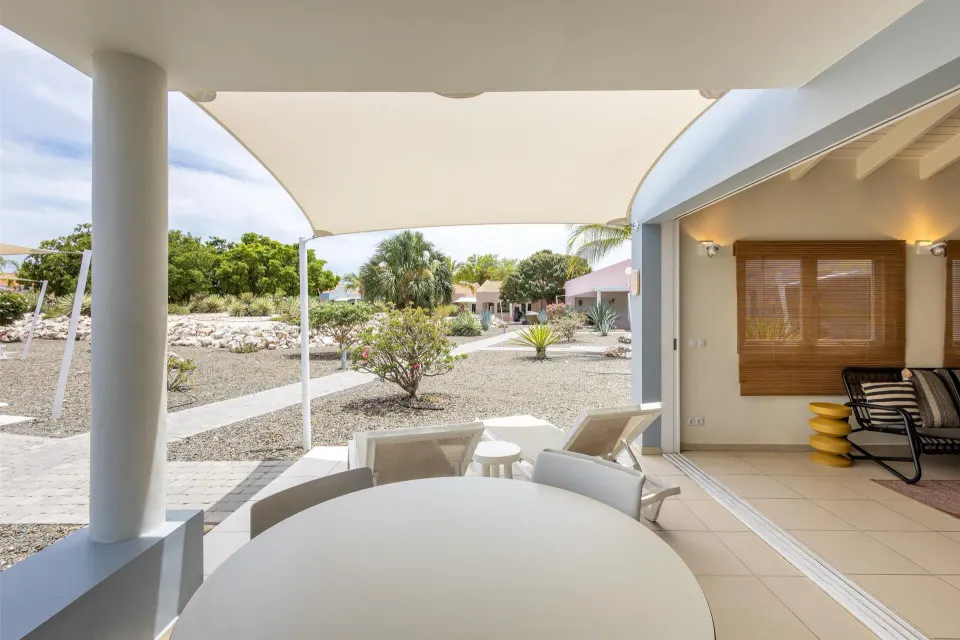 Covered garden-view patio with round table at Coral Estate Luxury Resort.