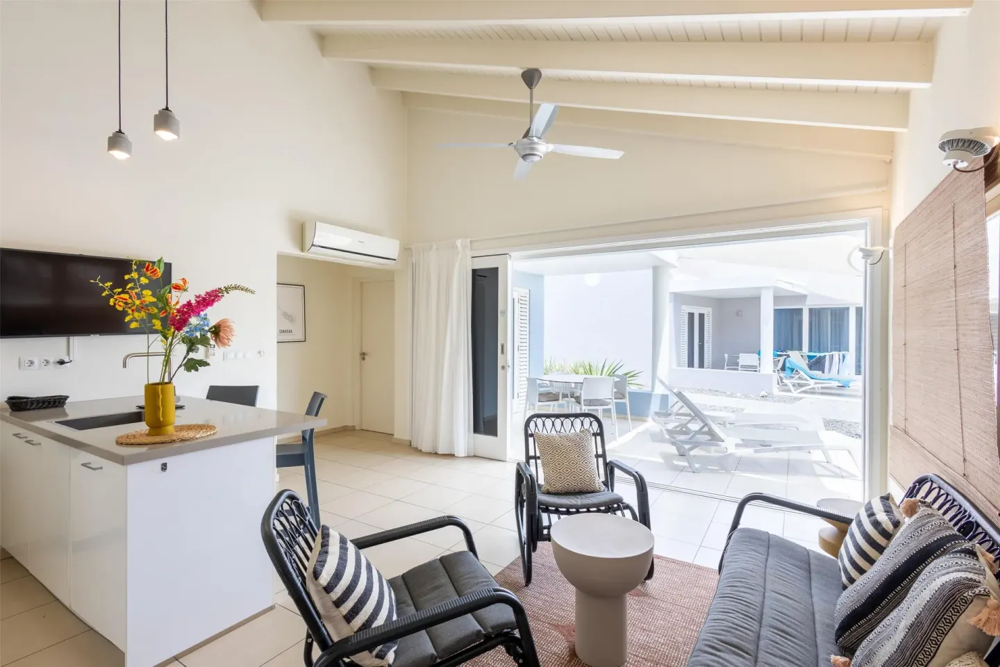 Apartment living area with kitchenette and patio view at Coral Estate Luxury Resort.