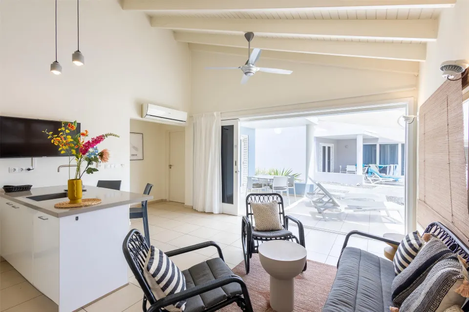 Apartment living area with kitchenette and patio view at Coral Estate Luxury Resort.