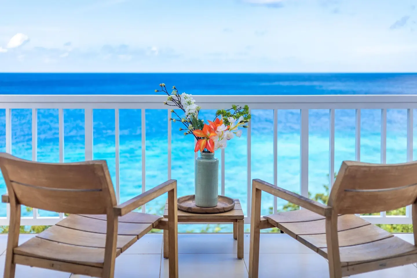 Superior Oceanfront balcony chairs facing the sea at Coral Estate Luxury Resort.